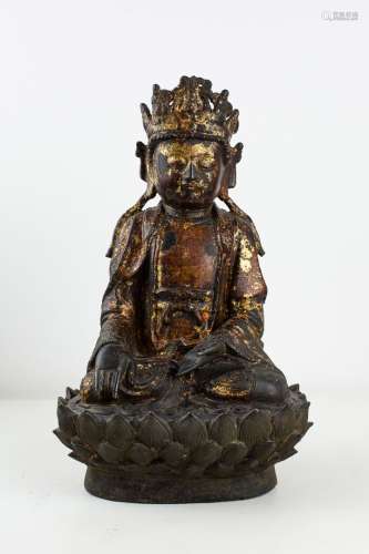 中国，明朝（1368-1644）。雕塑在圆形凹凸中描绘了观音菩萨在装饰有莲花花瓣的底座上坐于padmasana中，他的双手处于bhûmispashamudra（证地握手的位置）。他过去左手肯定带着一个装着柳枝的花瓶，这是他众多属性之一。他宁静的脸庞被高高的锻冠所覆盖。漆和镀金的青铜。高。颜色：28.5厘米，深度：11厘米。镀金和漆都不见了。