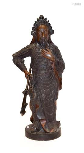 A Chinese Bronze Figure of a Guardian, 19th century, standing wearing scroll headdress and robes,