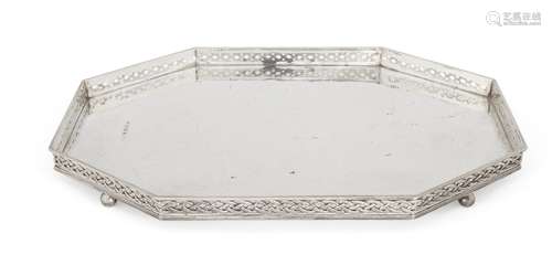 An elongated octagonal silver tray, Birmingham, c.1924, Albert Edward Jones, raised on four ball