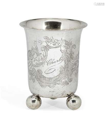 An engraved German silver beaker on three ball feet, stamped 800, the body of the beaker engraved