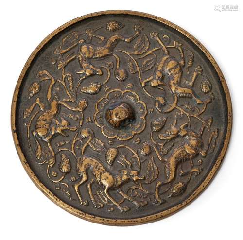 A Chinese copper alloy 'lion and grape' mirror, 18th century, cast with raised central loop knop