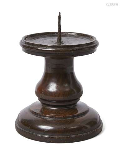 An English turned lignum vitae pricket candlestick, 17th century, the dished circular top with