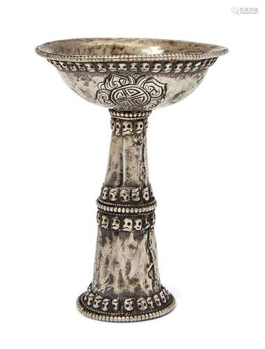 A Tibetan silver butter lamp, 18th/19th century, decorated with five bands of skulls, the