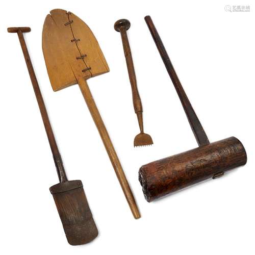 A collection of four treen tools, comprising a large pine mallet, 97cm high, an elm and ash iron-