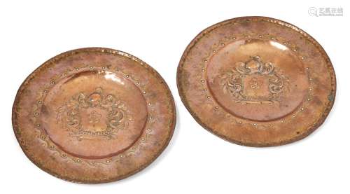 A pair of Italian copper chargers, 18th/19th century, each repousse decorated and centred by a