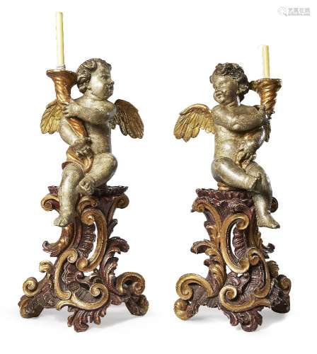A pair of Italian silvered and gilt figural candle holders, the cherubs 18th century, the bases late