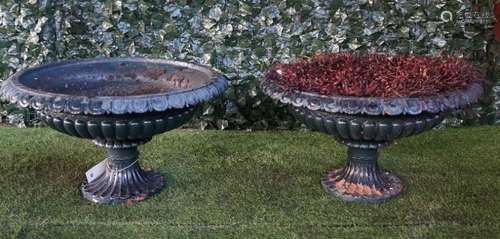 A pair of late 19th century green painted cast iron shallow jardinieres with fluted bodies and