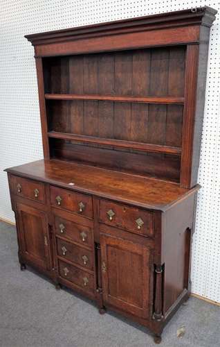 A George III oak dresser, the enclosed two tier plate rack, over six drawers and pair of cupboards,