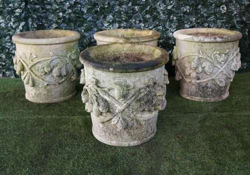 A set of four Vicenza stone jardinieres with fruit and leaf moulded bodies,