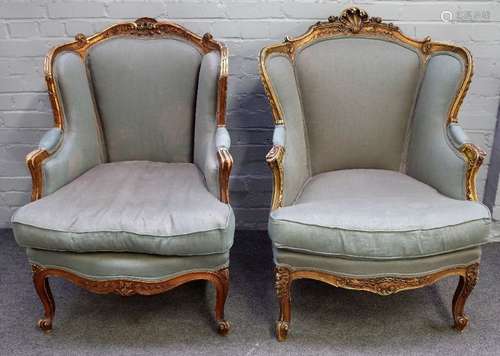 A pair of Louis XV style gilt framed tub back armchairs, with serpentine seats, on scroll supports,