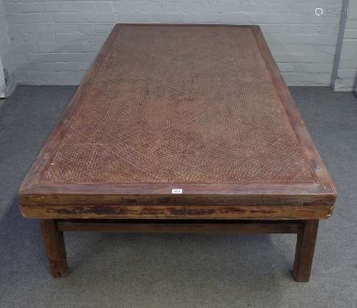 A 19th century Chinese elm framed opium bed, with rattan inset, on block supports,