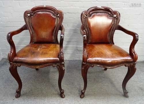 A pair of Victorian mahogany framed brown leather upholstered open armchairs,