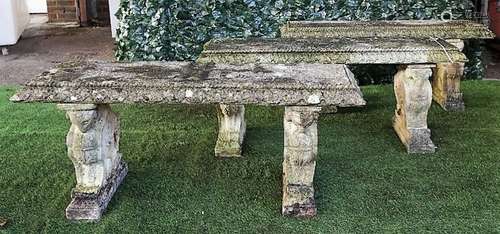 Three reconstituted stone garden benches, each on opposing beast moulded trestle end standards,