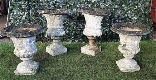 A pair of reconstituted stone jardinieres with flared rims and turned socles,