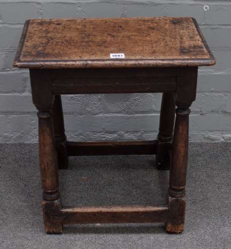 A 17th century oak joint stool, with moulded rectangular top, triangular carved friezes,