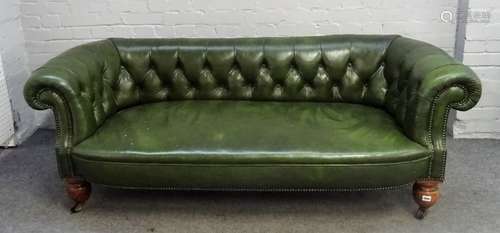 A Victorian green leather upholstered Chesterfield sofa, on bulbous turned mahogany supports,