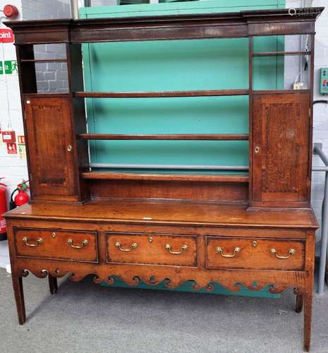 An 18th century mahogany banded oak dresser, the open three tier plate rack, with pair of cupboards,