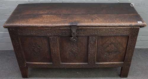 A late 17th century carved oak coffer, of panelled construction, with hinged top,