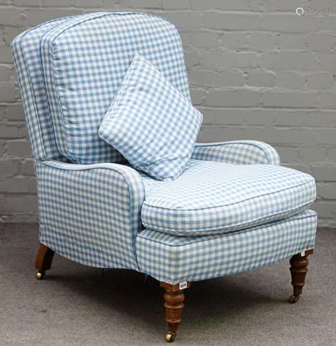 A Victorian oak framed easy armchair, with blue gingham upholstery, on turned supports,