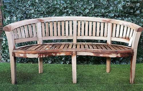 A teak framed semi-elliptic garden bench with slatted back and seat, on block supports,