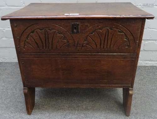 A small 17th century and later oak plank coffer, with carved front panel, on slab end supports,