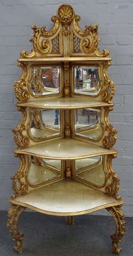 A late 19th century Italian Rococo revival white painted parcel gilt graduated corner shelf with