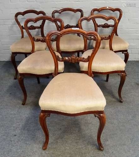 A set of six Victorian rosewood balloon back dining chairs with carved waist rail and serpentine