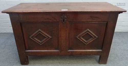 A 17th century oak coffer, with twin raised geometric panel front, on stile feet,