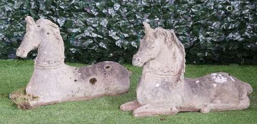 A pair of reconstituted stone figures of recumbent horses, each 80cm long x 55cm high, (2).