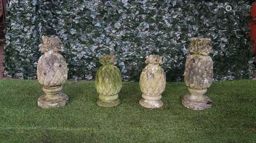 Two graduated pairs of reconstituted stone pineapple finials on turned socles,