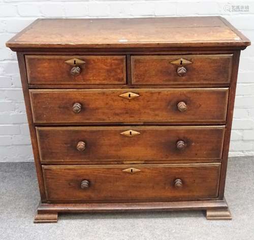 An 18th century oak chest of two short and three long graduated drawers on square bracket feet,