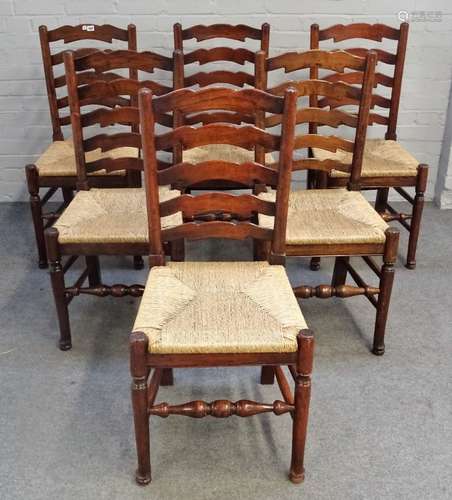 A set of six Lancashire ladder back rush seated dining chairs on turned supports,