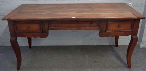 A 19th century French fruitwood writing desk with three frieze drawers on splayed supports,