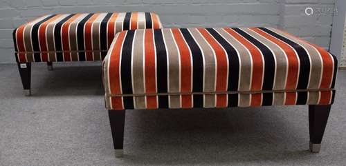 A pair of modern rectangular foot stools with striped upholstery on tapering ebonised supports,