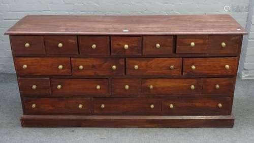 A 20th century hardwood low apothecary chest with nineteen various drawers on plinth base,