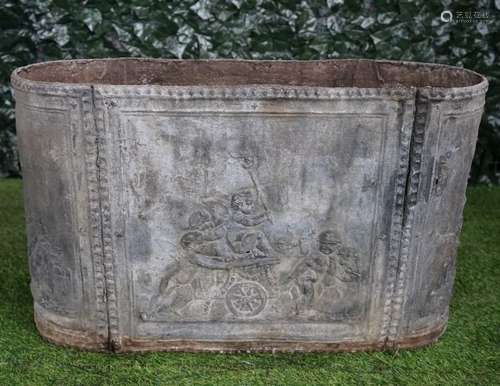 A rounded rectangular lead planter/cistern, relief cast with cherubs and chariots,