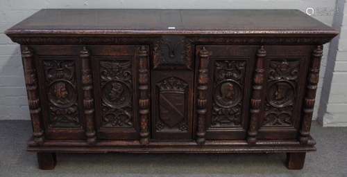 A French 16th century style oak cabinet with pair of profile carved figural doors divided by