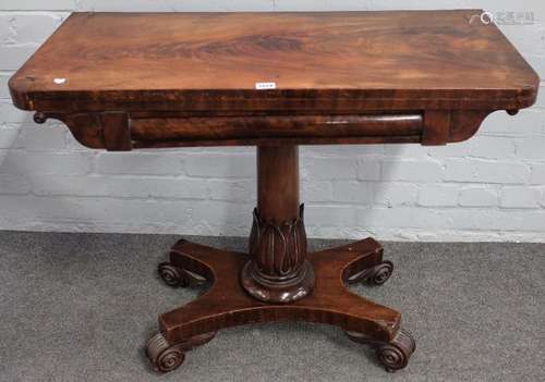 A Regency mahogany card table on carved and turned column and four scroll feet,