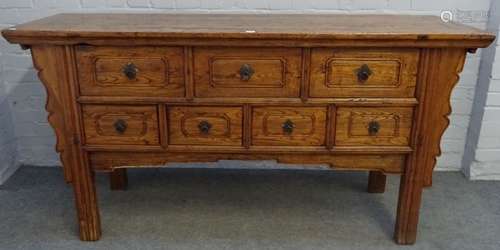 A Chinese elm side cabinet with seven frieze drawers flanked by shaped sides on block supports,