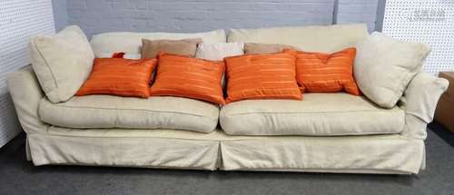 A large modern square back sofa with cream loose covers, 255cm wide x 65cm high.