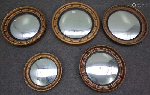 A group of five Regency style gilt framed circular convex wall mirrors, the largest, 48cm diameter,