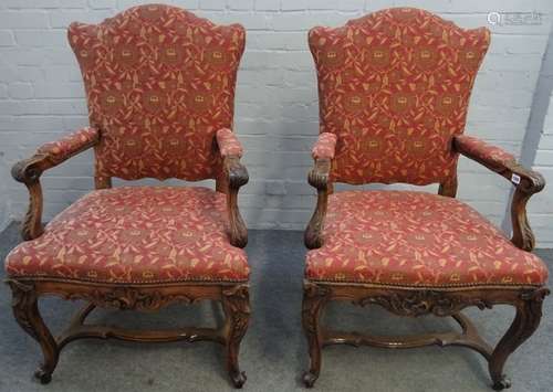 A pair of French 19th century walnut fauteuils with shaped backs and open arms on carved cabriole