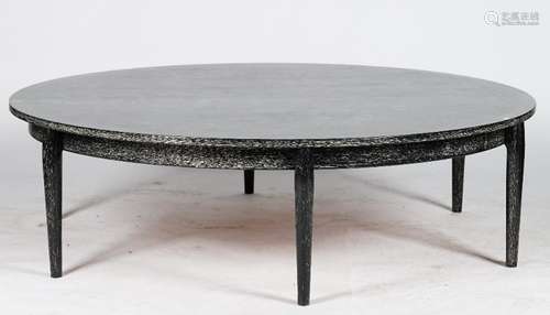 A circular ebonised low centre table, with ceruse finish, on rounded tapering legs, 156cm diameter.