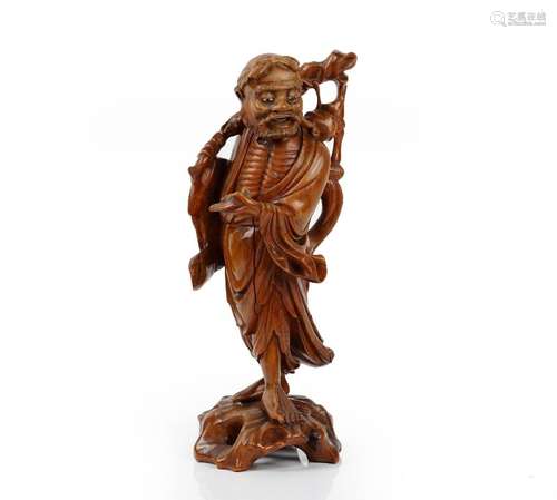 A Chinese carved wood figure of a man, 20th century, carved carrying a branch over his shoulder,