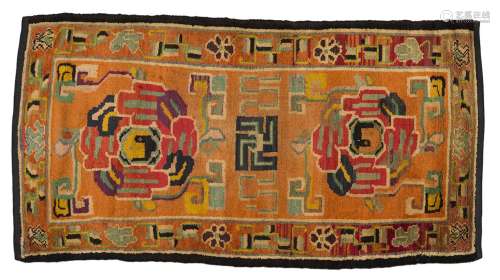 地毯西藏羊毛。145 x 77 cm橙色背景上的风格化花卉装饰，构图中心有一个