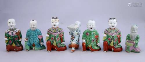 中国-嘉庆时代（1796-1820）。  瓷器上的七人，跪着，拿着如意、小花瓶或容器，衣服上装饰着花。  高度从14.5到17.5厘米。(修复、小的缺失和碎片)