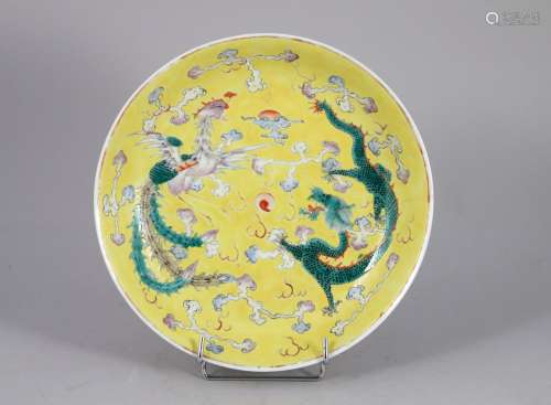 中国--20世纪初。  黄底多色釉瓷浮雕，饰龙凤呈祥云绕圣珠。  背面铁红的光绪印。  直径25.7厘米。(珐琅质的裂纹、磨损)