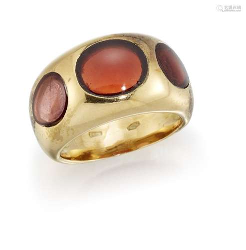 A garnet three stone ring, composed of a central oval cabochon garnet between pear shaped cabochon