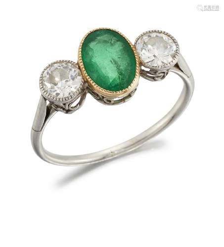 An early 20th century emerald and diamond three stone ring, the central oval emerald between old-