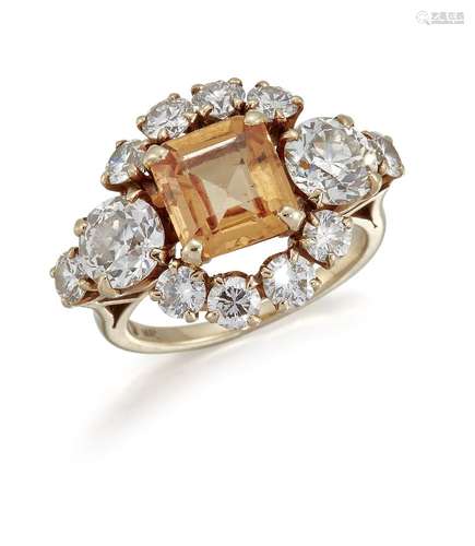 A topaz and diamond cluster ring, the central cut-cornered square pale orange topaz between old-